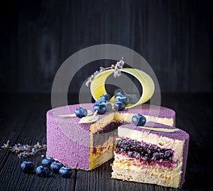 Delicious lavender cake with blueberries on wooden table