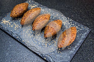 Delicious Lebanese  food, kibbeh kibe on black slate stone and granite background