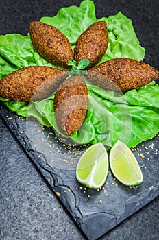 Delicious Lebanese  food, kibbeh kibe on black slate stone and granite background