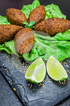 Delicious Lebanese  food, kibbeh kibe on black slate stone and granite background