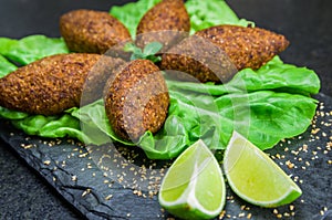 Delicious Lebanese  food, kibbeh kibe on black slate stone and granite background