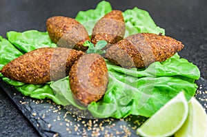 Delicious Lebanese  food, kibbeh kibe on black slate stone and granite background