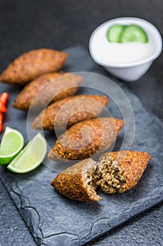 Delicious Lebanese  food, kibbeh kibe on black slate stone and granite background