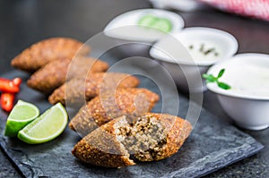 Delicious Lebanese  food, kibbeh kibe on black slate stone and granite background