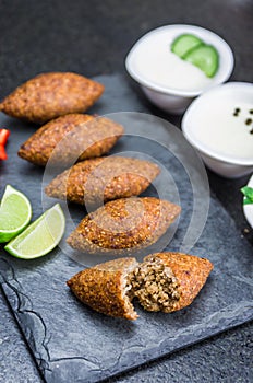 Delicious Lebanese  food, kibbeh kibe on black slate stone and granite background