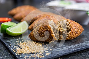 Delicious Lebanese  food, kibbeh kibe on black slate stone and granite background