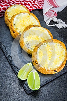 Delicious Lebanese food, sfiha au gratin with labneh and cheese on black slate stone background and traditional Lebanese keffiyeh