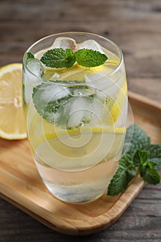 Delicious lemonade made with soda water and fresh ingredients on wooden table, closeup