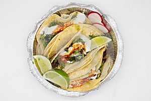 Delicious Lengua Tacos with Limes and Sour Cream in a Takeout Container photo