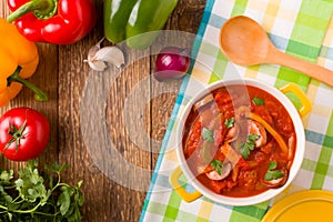 Delicious letcho with fresh vegetables, served in a yellow pot with the fresh bun