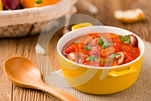 Delicious letcho with fresh vegetables, served in a yellow pot with the fresh bun