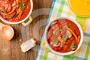 Delicious letcho with fresh vegetables, served in a yellow pot with the fresh bun