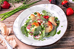 Delicious light salad with grilled shrimps, strawberries, arugula, parsley, spinach and scallion, sprinkled with fried sesame