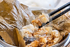 Delicious Lo Mai Gai dim sum, fresh steamed glutinous rice with chicken roll wrapped by lotus leaf in bamboo steamer in hong kong