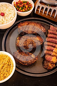 Delicious looking meal of grilled steak, a bowl of cooked rice, and several vegetables