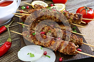 Delicious lula kebab on a wooden table. Chopped meat on wooden skewers, grilled.