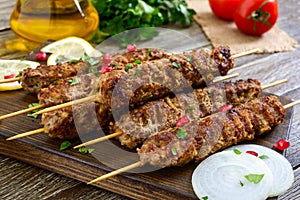 Delicious lula kebab on a wooden table. Chopped meat on wooden skewers, grilled.