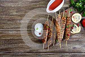 Delicious lula kebab on a wooden table. Chopped meat on wooden skewers, grilled. Eastern cuisine.