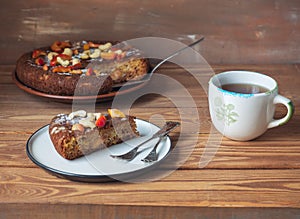 Delicious lunch with apple pie on two plates and tea in a white mug on a brown background