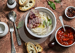 Delicious lunch - bean puree with bacon, tomato sauce with carrots and onions, homemade bread, fresh cucumber on a stone