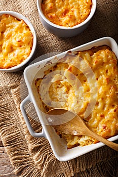 Delicious mac and cheese in a baking dish close-up on a table. V