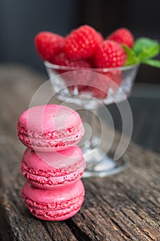 Delicious macarons raspberry flavored with a glass filled with f