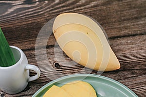 Delicious mango sticky rice serve with coconut milk on wooden table.