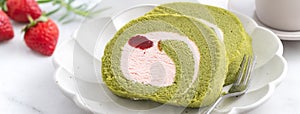 Delicious Matcha Swiss Roll Cake slices with strawberry cream on white background