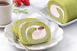 Delicious Matcha Swiss Roll Cake slices with strawberry cream on white background