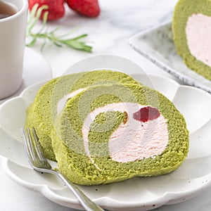 Delicious Matcha Swiss Roll Cake slices with strawberry cream on white background