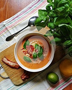 Delicious meal. Tomatoe cream soup with basil, cheese, bacon and lime photo