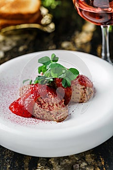 Delicious meat pate foie gras on plate with berry sauce, sprouts and toasts on marble background with drinks. Healthy food, close