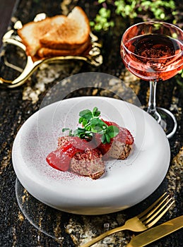 Delicious meat pate foie gras on plate with berry sauce, sprouts and toasts on marble background with drinks. Healthy food, top