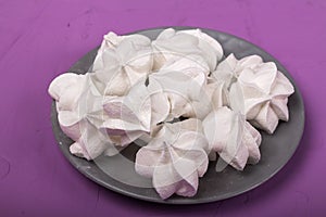 delicious meringue on gray plate on a purple background
