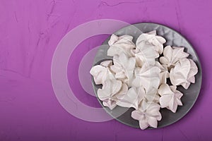 delicious meringue on gray plate on a purple background