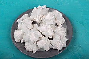 delicious meringue on gray plate on turquoise background