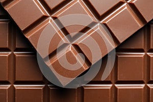 Delicious milk chocolate bars as background, top view