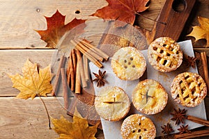 Delicious mini apple pies on rustic wooden table. Autumn pastry desserts.