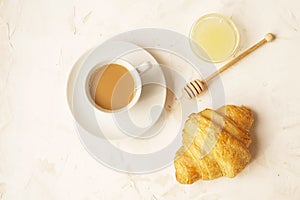 Delicious morning coffee cup with croissant close up on white