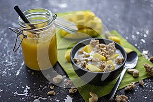 Delicious muesli with fresh mango pieces, cashew nuts and yoghurt with a smoothie