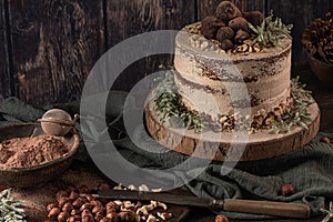 Delicious naked chocolate and hazelnuts cake on table rustic wood kitchen countertop