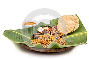 Delicious nasi briyani meal with mutton, dhal on banana leaf