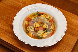 Delicious noodle soup with vegetables, noodle soup with vegetables, on a wooden background, red fabric background, with toast,