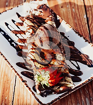 Delicious nutella and chocolate syrup crepe, with a scoop of ice cream