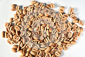 Delicious and nutritious peanuts, peeled in a heart-shaped bowl with overhead view isolated on wooden table