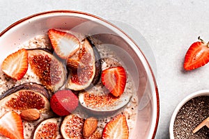 Delicious oatmeal with fig pieces, strawberries and chia seeds on a light background. superfood concept. Healthy, clean eating.