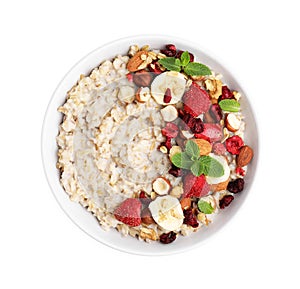 Delicious oatmeal with freeze dried berries, banana, nuts and mint on white background, top view