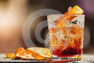 Delicious old fashion cocktail in the etched glass with ice and orange slices. Shallow dof.