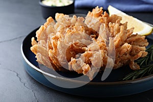 Delicious onion blossom served on black table, closeup