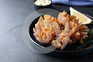 Delicious onion blossom served on black table, space for text